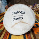 Underside of Navajo Sunface Kachina doll base with handwritten figure name and artist surname.