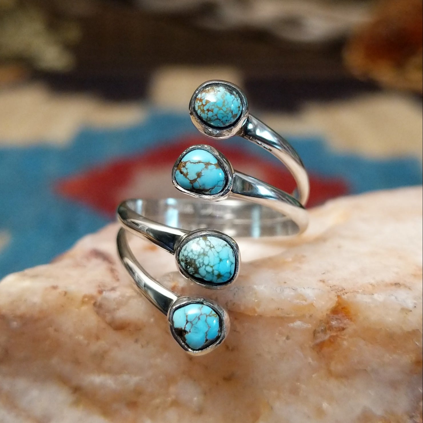 Sterling silver ring with #8 turquoise set in individual, round bezels suspended on strands of silver.