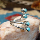 Sterling silver ring with #8 turquoise set in individual, round bezels suspended on strands of silver.