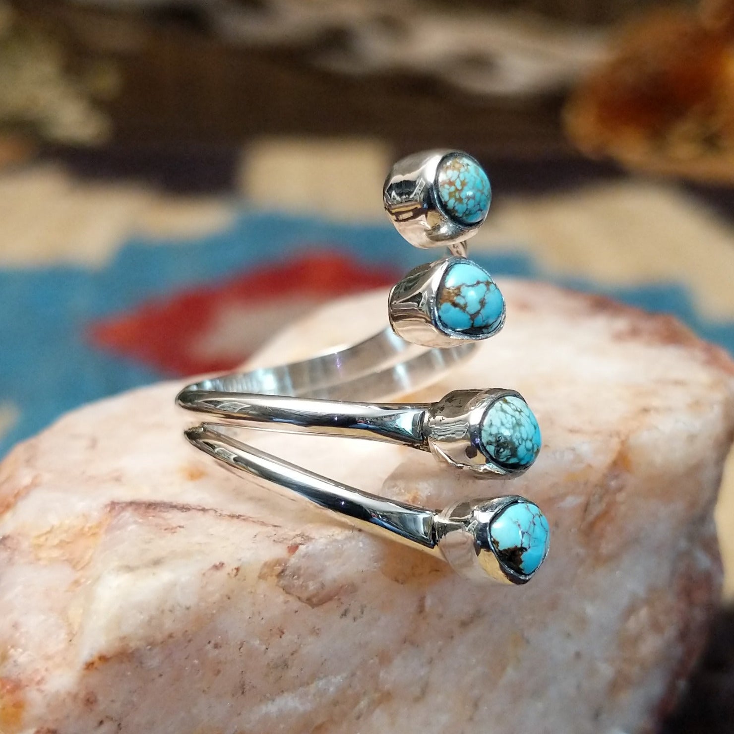Sterling silver ring with #8 turquoise set in individual, round bezels suspended on strands of silver.