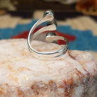 Sterling silver ring with #8 turquoise set in individual, round bezels suspended on strands of silver.