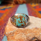 #8 Turquoise Ring by Terry Wood featuring a square turquoise stone with prominent natural brown matrix, set in Sterling Silver with geometric openwork detailing along the band.