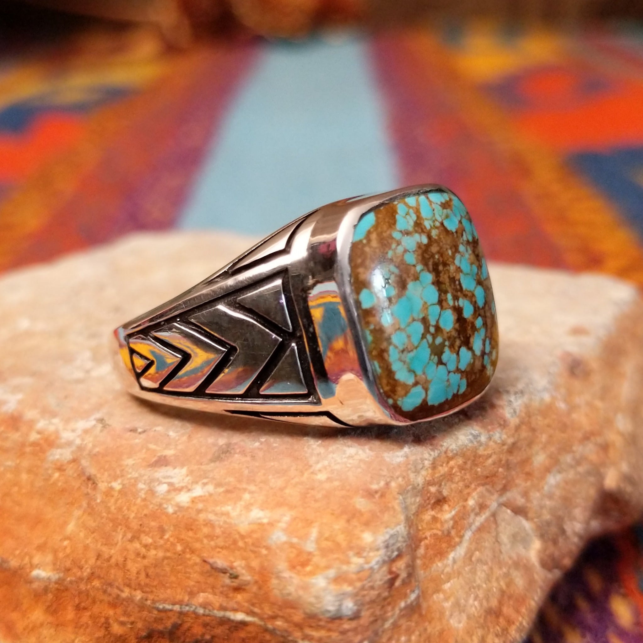 #8 Turquoise Ring by Terry Wood featuring a square turquoise stone with prominent natural brown matrix, set in Sterling Silver with geometric openwork detailing along the band; side view.