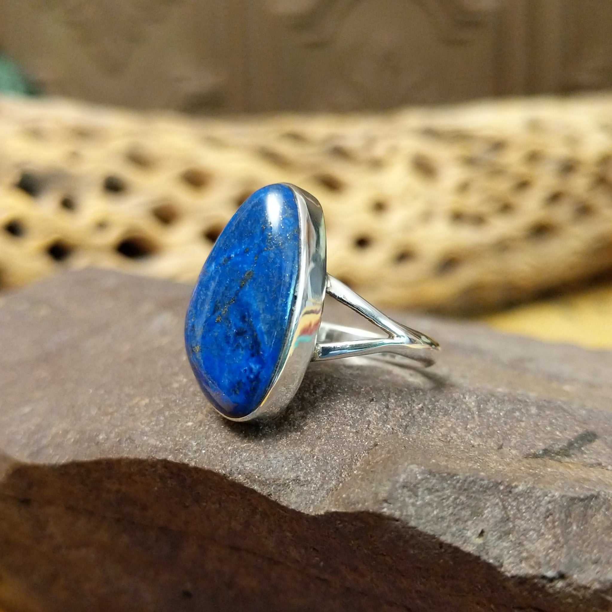 Abstract lapis ring by Cathy Webster, featuring a deep blue lapis stone with natural pyrite flecks set in a handcrafted sterling silver contemporary design.  Side view.