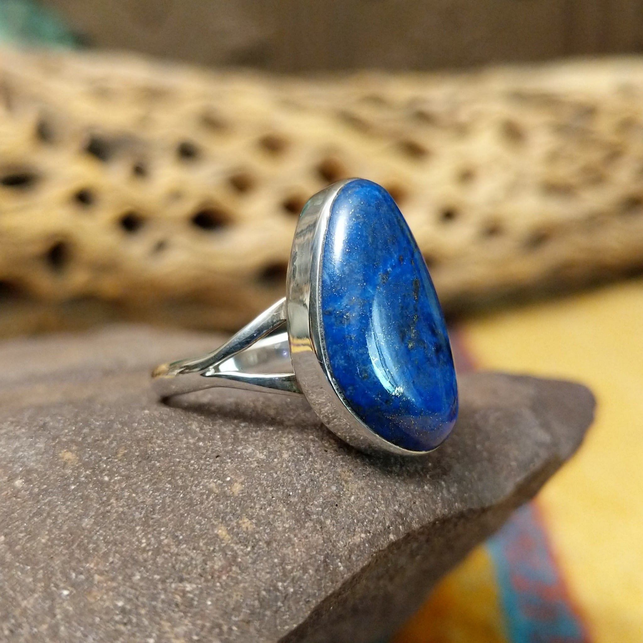 Abstract lapis ring by Cathy Webster, featuring a deep blue lapis stone with natural pyrite flecks set in a handcrafted sterling silver contemporary design.  Side view.