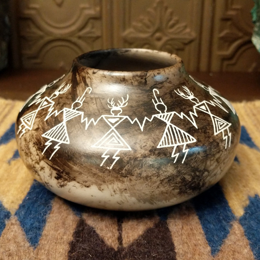 Etched friendship dancers on the white clay surface with horsehair fired onto the body, making striking contrast.