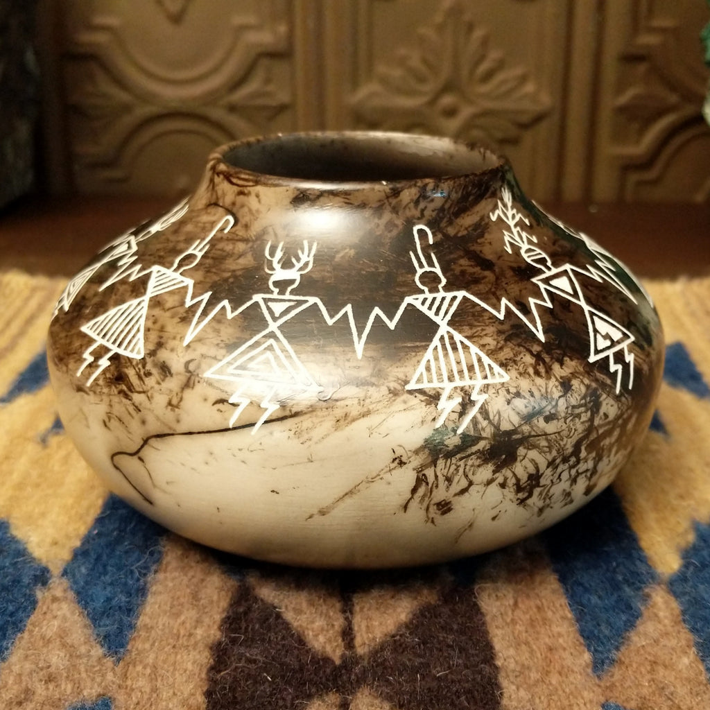 Etched friendship dancers on the white clay surface with horsehair fired onto the body, making striking contrast.