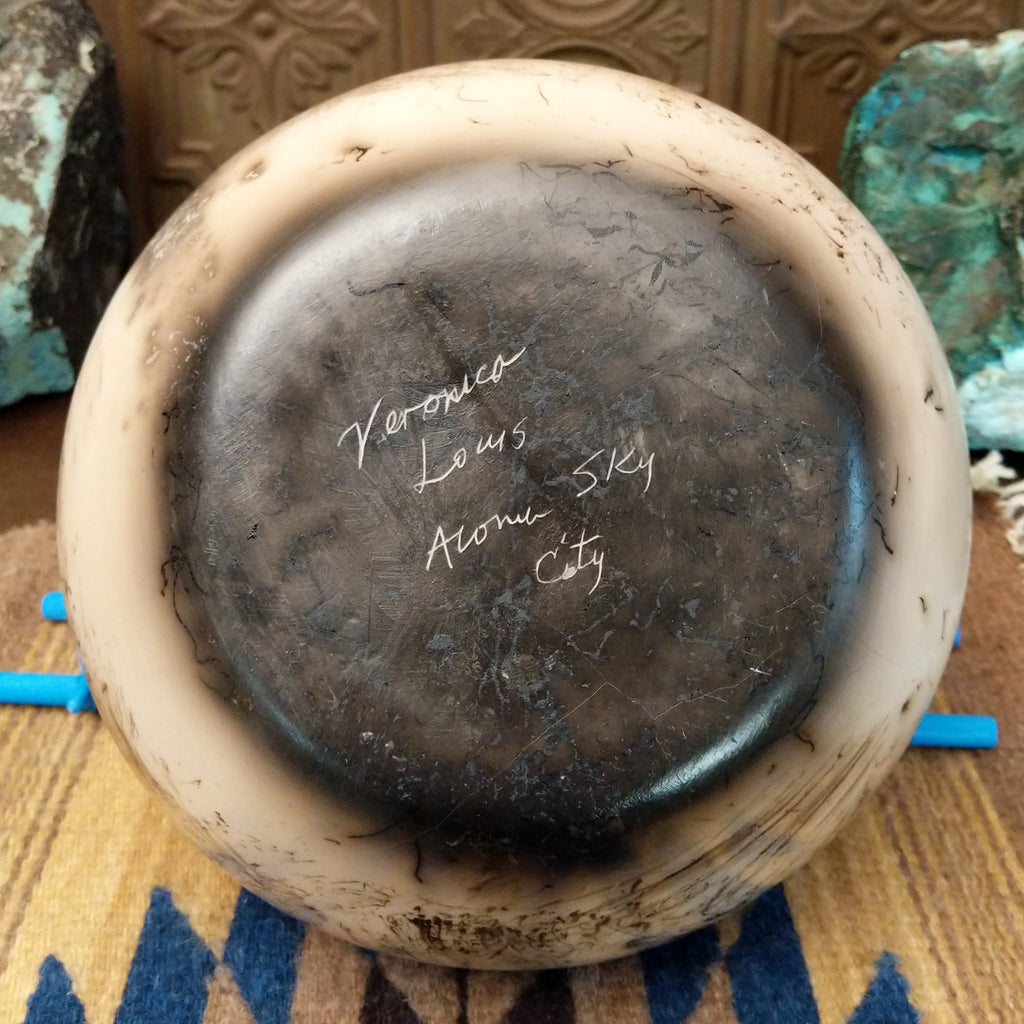 The artisan's etched signature found on the underside of the piece.
