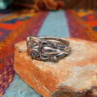 Adorned Silver Ring by Bobby Platero with central stamped rosette and layered silverwork.