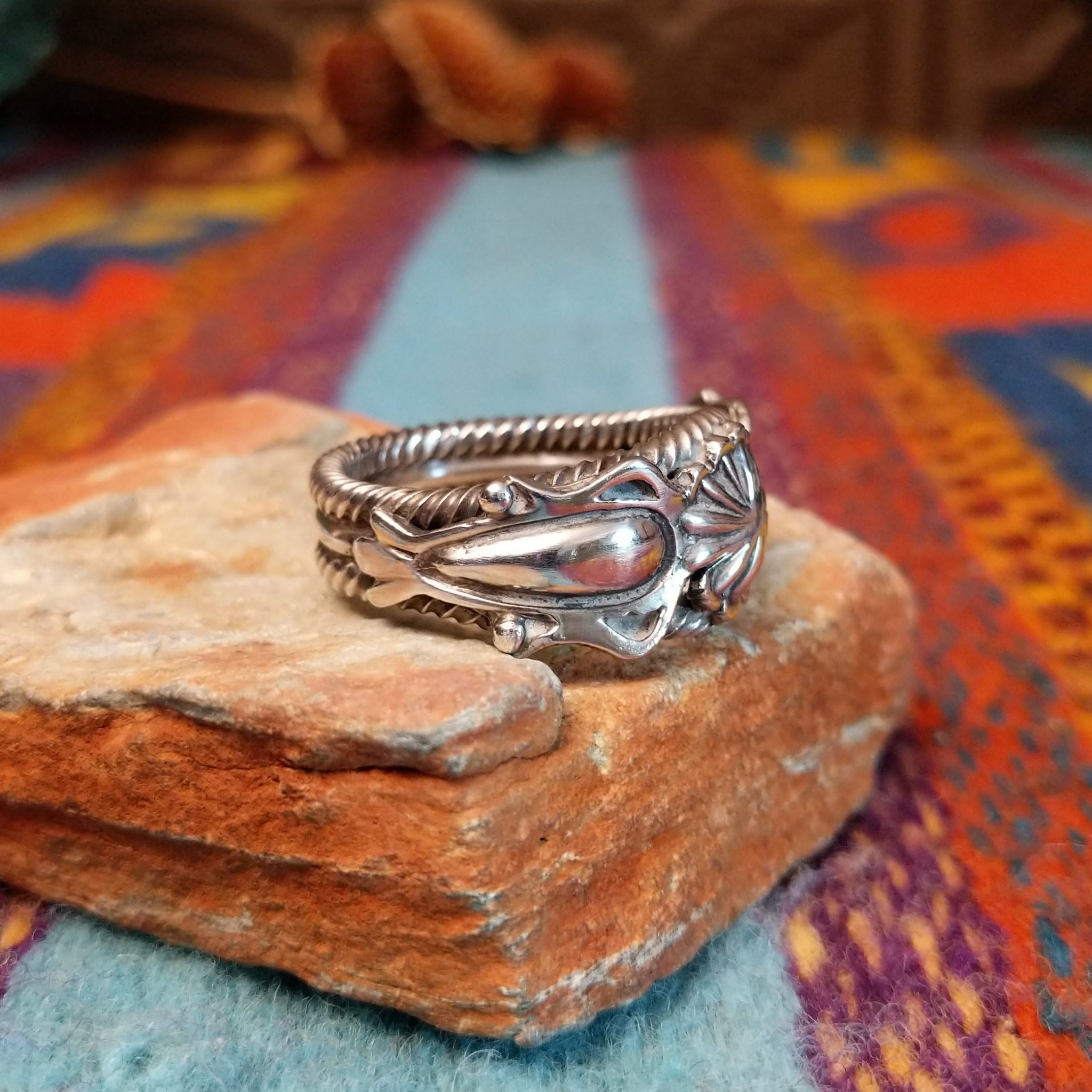 Adorned Silver Ring by Bobby Platero with central stamped rosette and layered silverwork.
