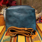 Alexa Handbag by Liz Soto featuring a tall structured silhouette, decorative contrast stitching, vertical center detailing, large wrapped circular accent, and wide shoulder strap.