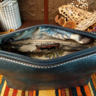 Alexa Handbag by Liz Soto featuring a tall structured silhouette, decorative contrast stitching, vertical center detailing, large wrapped circular accent, and wide shoulder strap; interior.