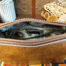 Alexa Handbag by Liz Soto featuring a tall structured silhouette, decorative contrast stitching, vertical center detailing, large wrapped circular accent, and wide shoulder strap; interior.