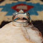 Amethyst ring by Ann Curley, featuring four faceted purple amethyst gemstones in round, square, rectangular, and pear shapes set in a handcrafted sterling silver ring.  Underside view.