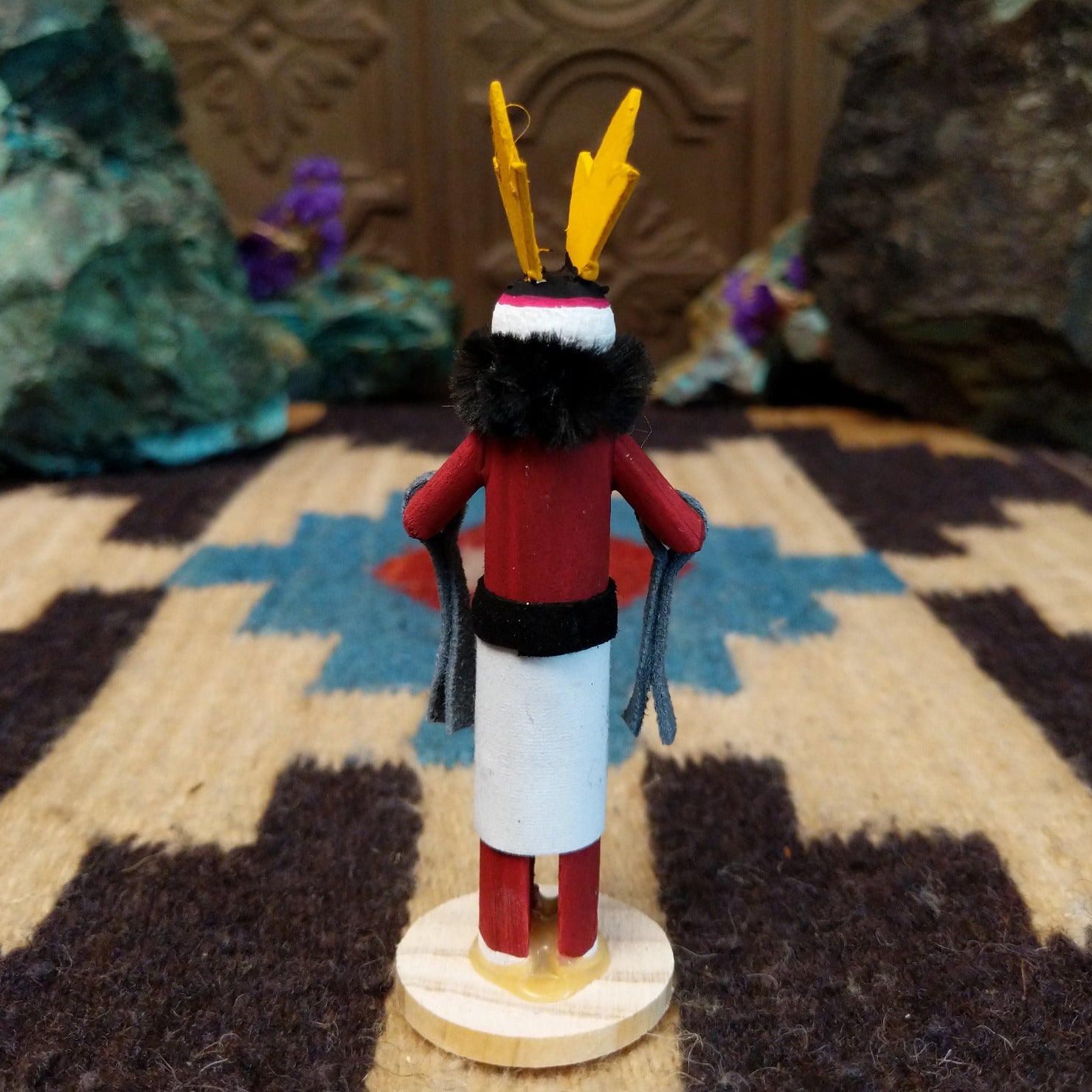 Mini antelope kachina by Rosalind Grey with yellow horns, red body, black fur collar, and white geometric-patterned garment.