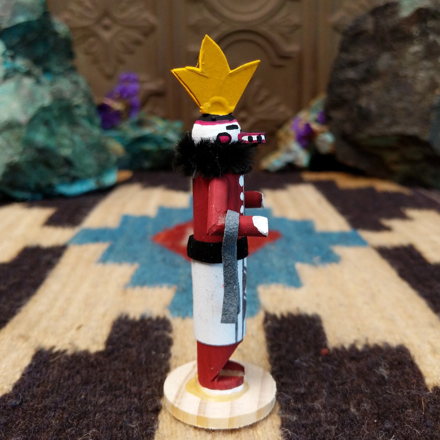 Mini antelope kachina by Rosalind Grey with yellow horns, red body, black fur collar, and white geometric-patterned garment.