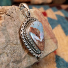 Sterling silver pendant with Arizona blue opal set in the bezel, framed by ornate silverwork.