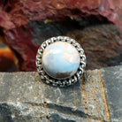 Ring features a large, dome-shaped blue opal set in a twisted silver band.