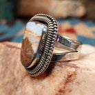 Sterling silver ring with Arizona blue opal set in the large bezel, framed by ribbed silverwork.