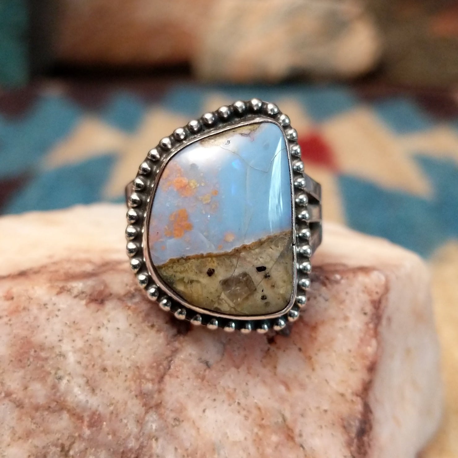 Sterling silver ring with Arizona blue opal set in the bezel, framed by dotted accents.
