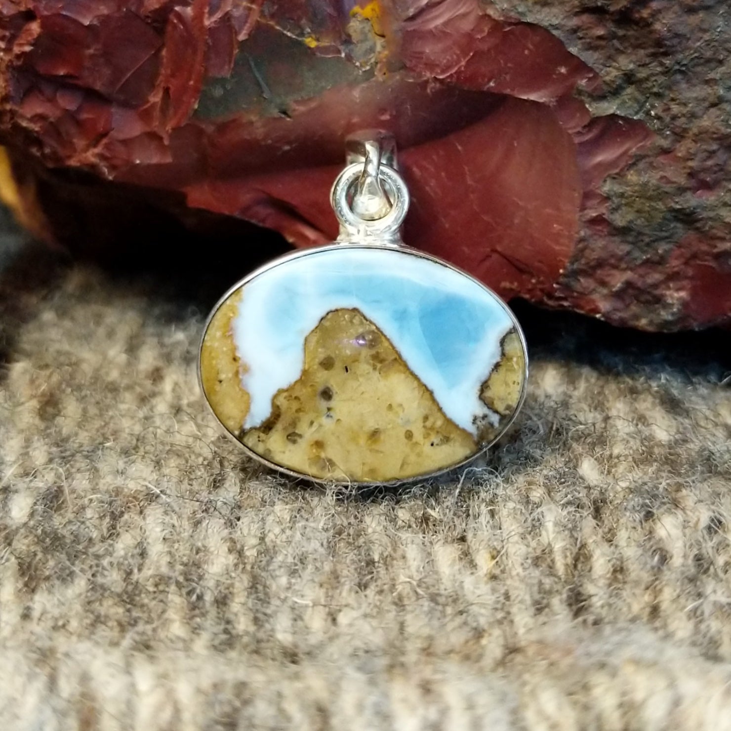 An oval Arizona Blue Opal pendant in a sterling silver setting.