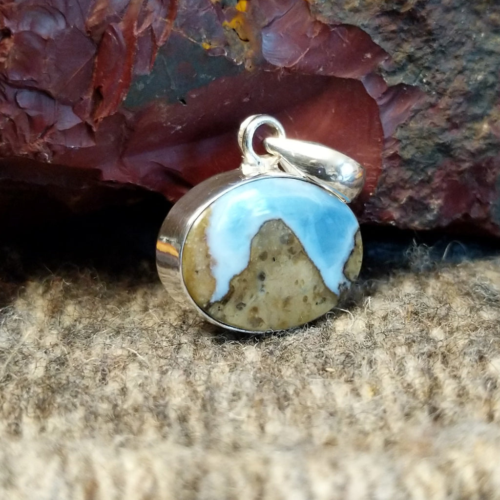 An oval Arizona Blue Opal pendant in a sterling silver setting.