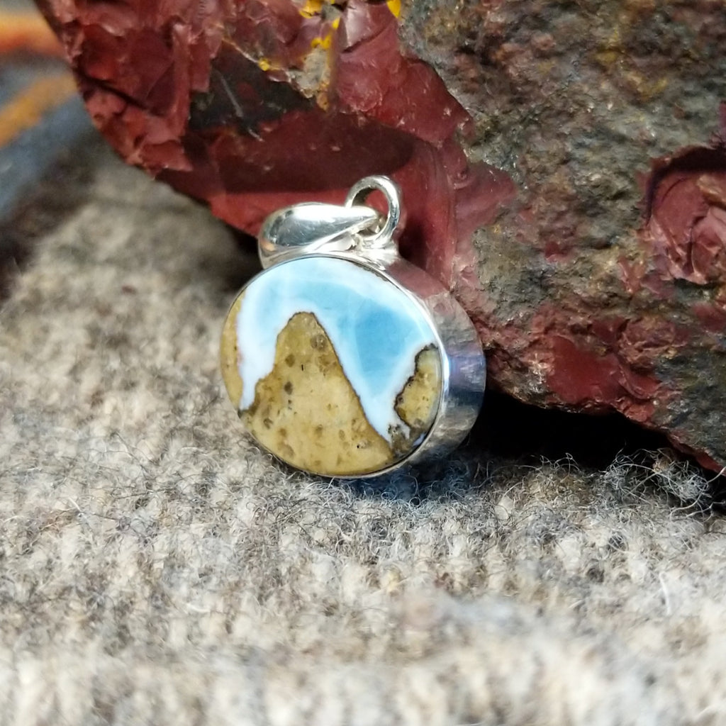 An oval Arizona Blue Opal pendant in a sterling silver setting.