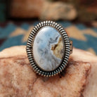 Sterling silver ring with Arizona blue opal set in the oval bezel, framed by ribbed silverwork.