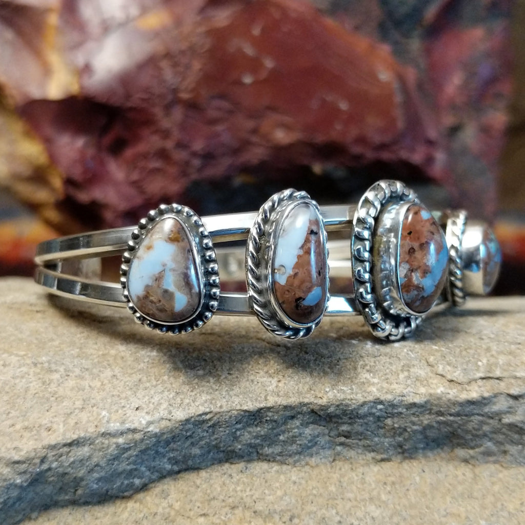 A sterling silver cuff featuring five Arizona Blue Opal stones.