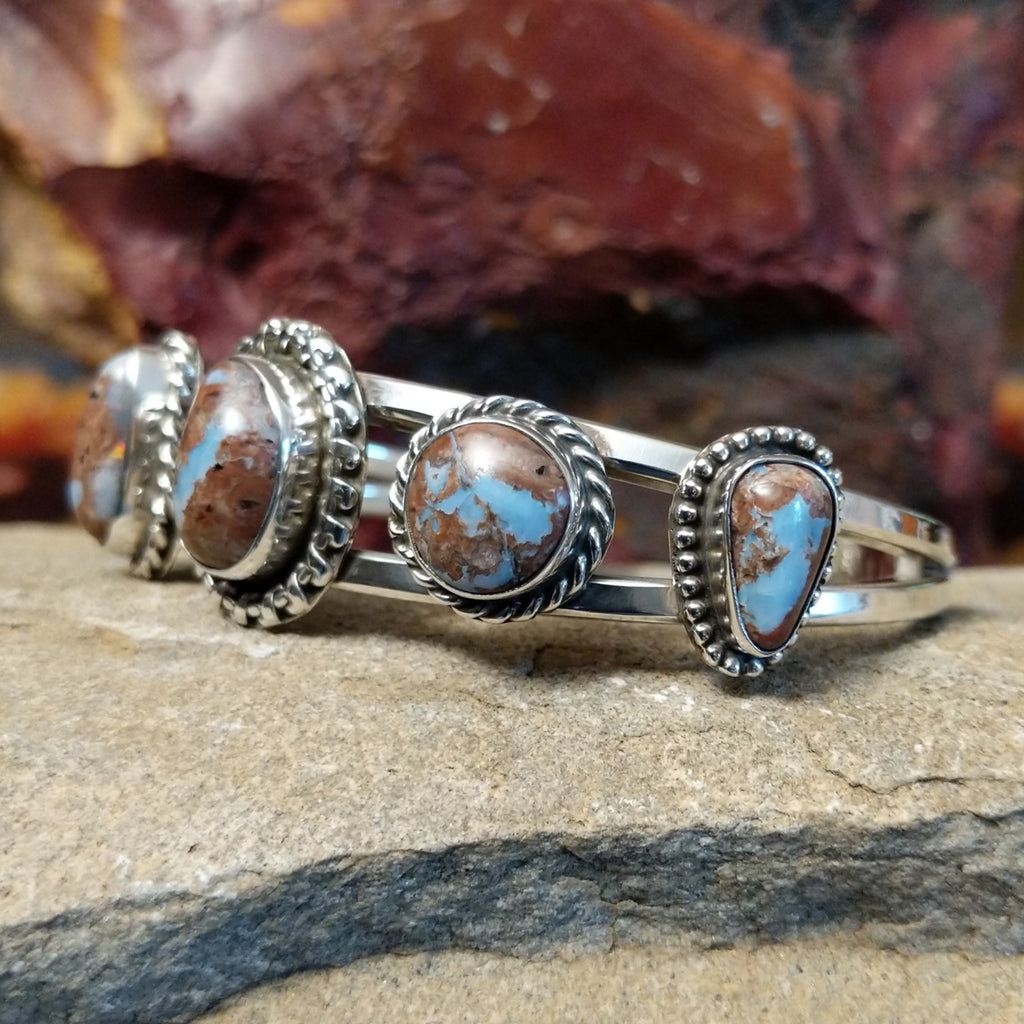 A sterling silver cuff featuring five Arizona Blue Opal stones.