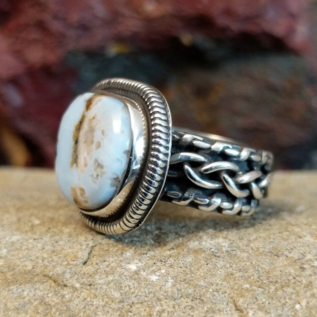 A sterling silver ring featuring a cushion-cut Arizona Blue Opal framed by a twisted rope bezel.