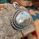 Sterling silver pendant with Arizona blue opal set in the bezel, framed by ornate silverwork accents.
