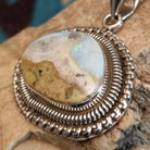 Sterling silver pendant with Arizona blue opal set in the bezel, framed by ornate silverwork accents.