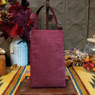 Aztec Club Bag by Bamboo Trading featuring intricate turquoise, pink, plum, and purple geometric patterns with diamond motifs, embroidered details, shimmering beadwork, sequins, and a coordinating burgundy shoulder strap; back side view.