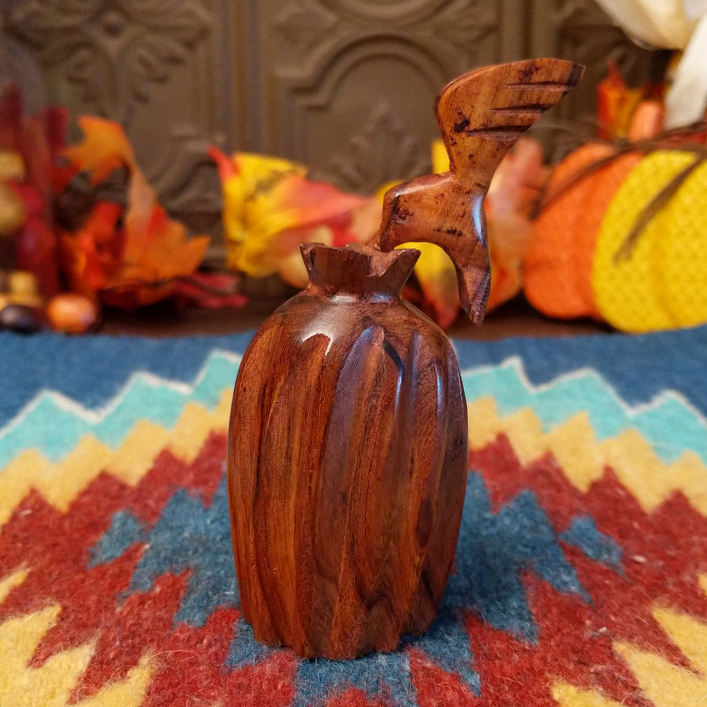 Wooden barrel cactus with a hummingbird on top.