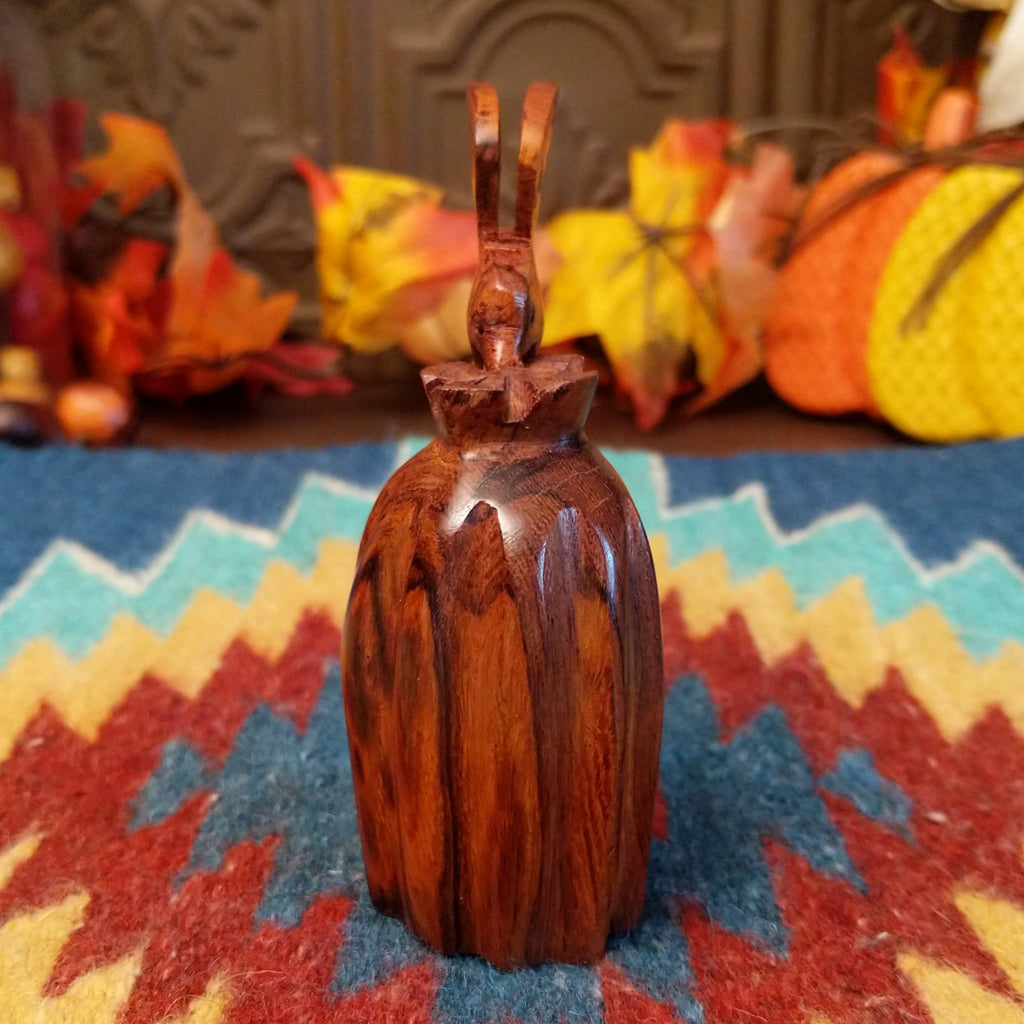 Wooden barrel cactus with a hummingbird on top.