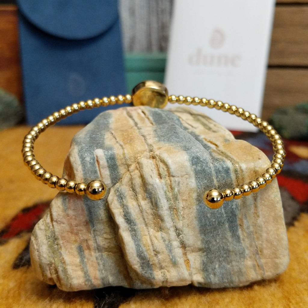 Beaded cuff bracelet with a gold-plated brass frame.