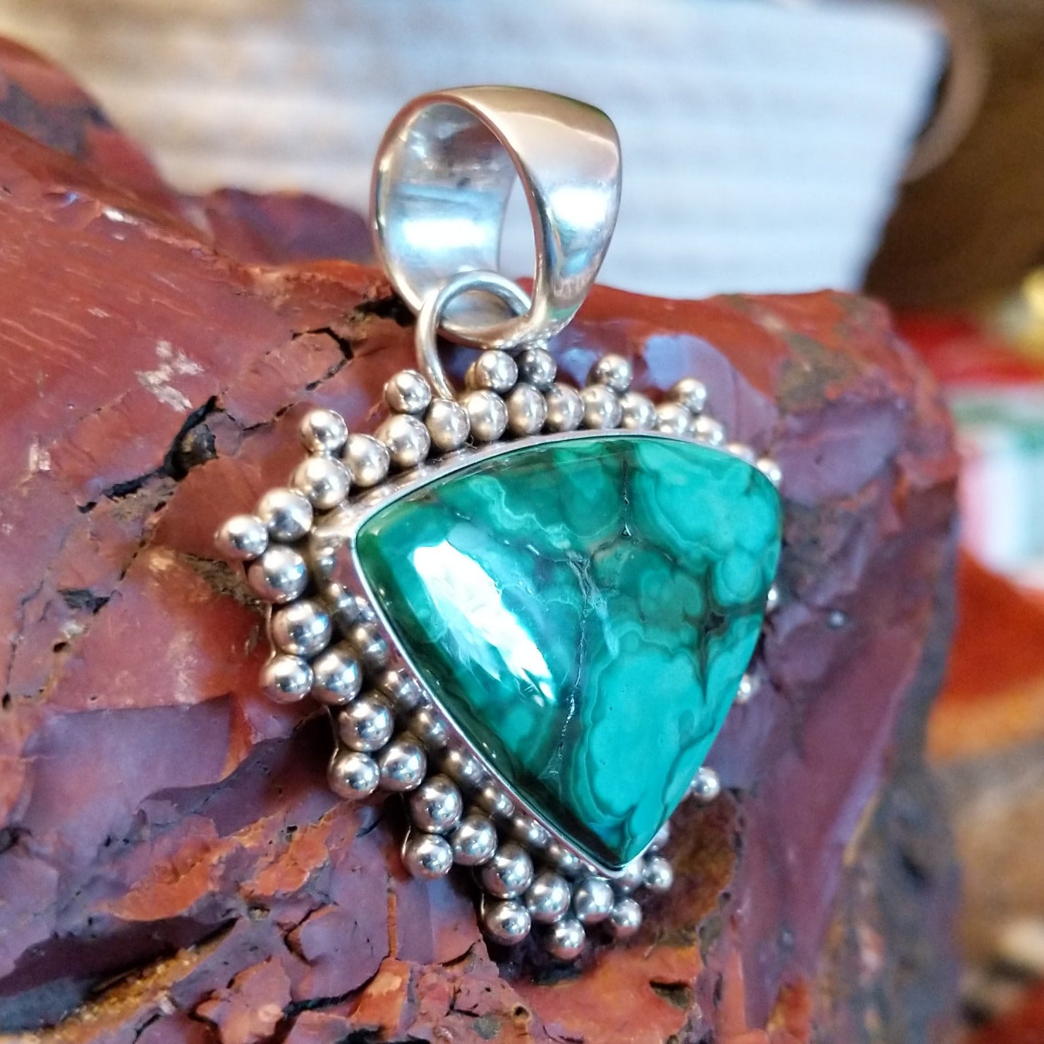 Triangular sterling silver pendant with malachite set within the bezel and dotted accents.
