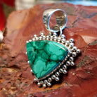 Triangular sterling silver pendant with malachite set within the bezel and dotted accents.