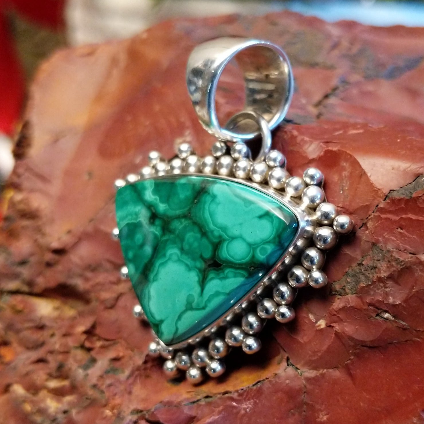 Triangular sterling silver pendant with malachite set within the bezel and dotted accents.