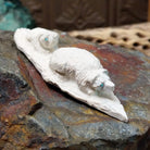 Zuni bear cub fetish carving by Adrian Cachini featuring two white stone bears with turquoise inlaid eyes resting on a carved base.