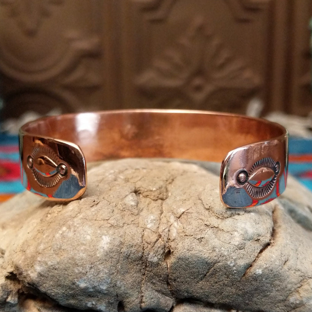 Copper and sterling silver cuff with bear paw patterned stamps.