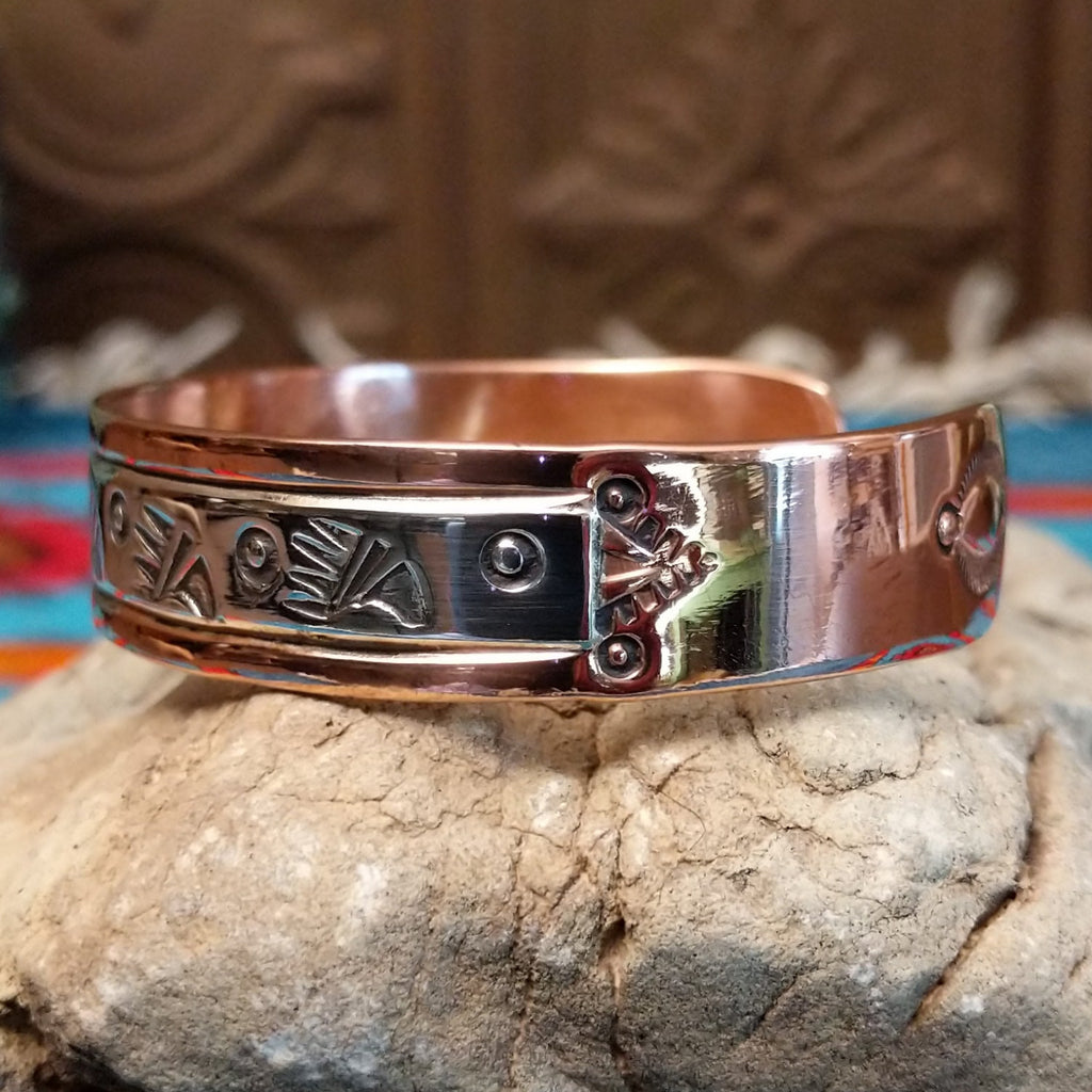 Copper and sterling silver cuff with bear paw patterned stamps.