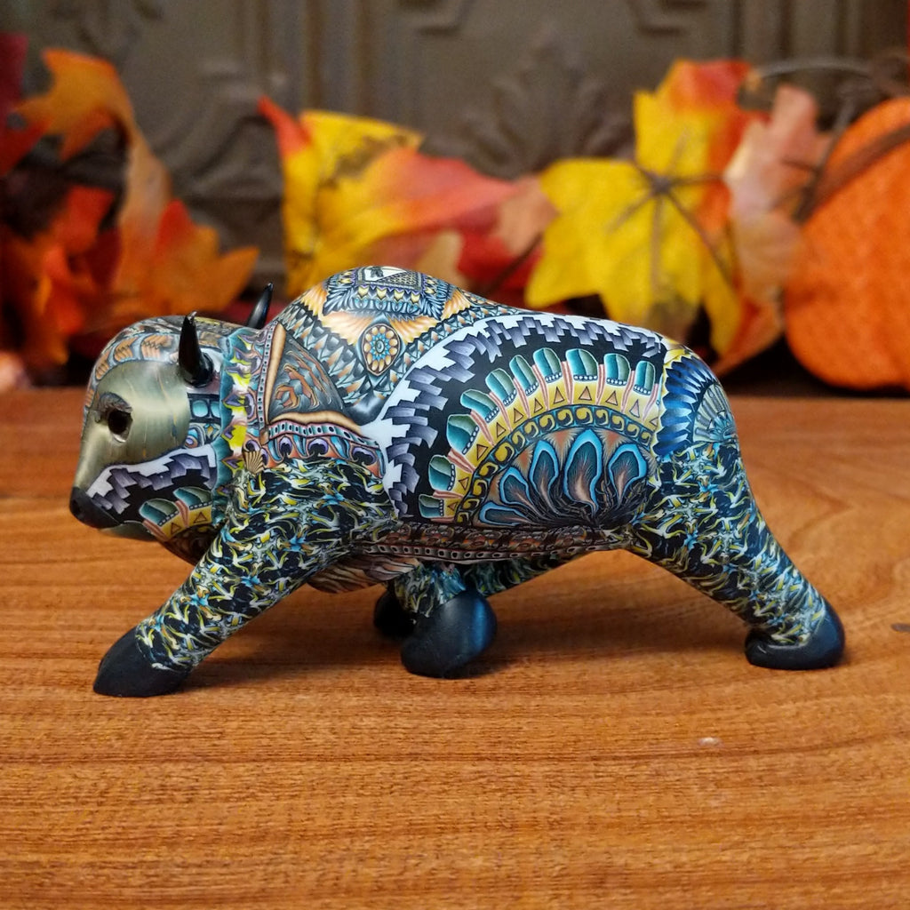 Decorative buffalo figurine with intricate patterns on a wooden surface