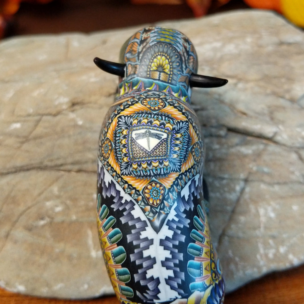 Decorative buffalo figurine with intricate patterns on a stone surface