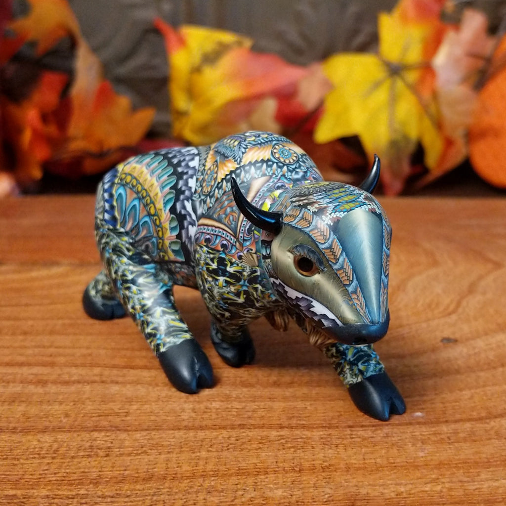 Decorative figurine of a buffalo with intricate patterns on a wooden surface.