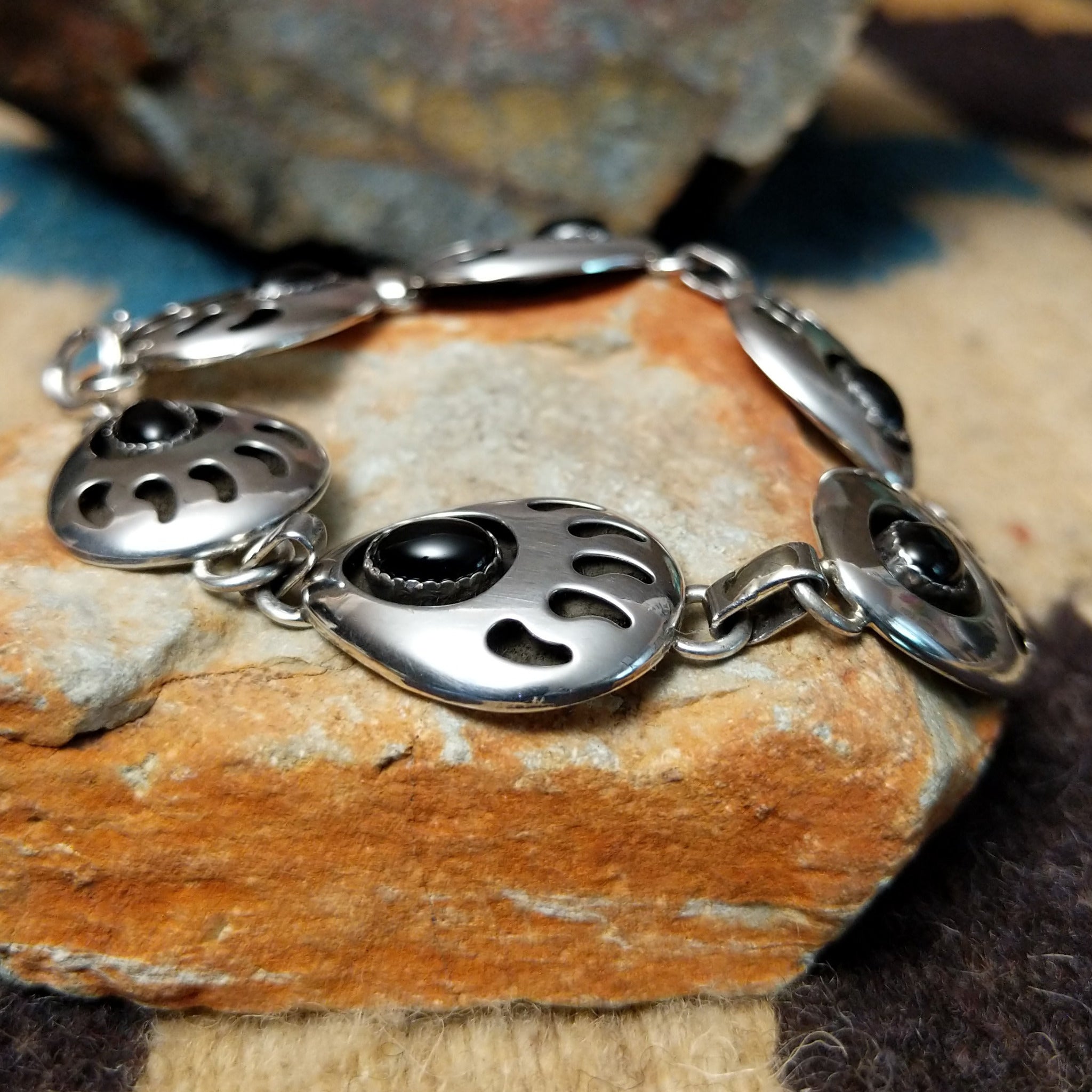 Sterling silver bear paw shadowbox bracelet by George Jones with a black onyx stone and hand-stamped Southwestern details.