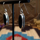 Sterling silver earrings with black onyx set in oval bezels, framed by twisted rope accents.