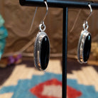 Sterling silver earrings with black onyx set in oval bezels, framed by twisted rope accents.