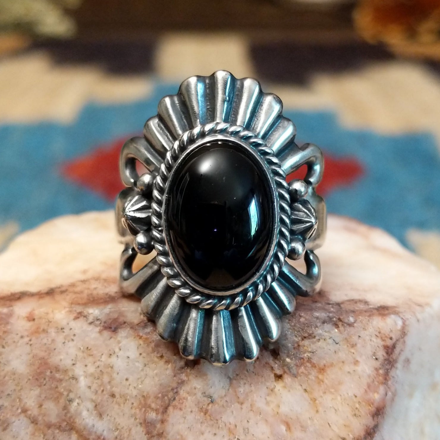 Sterling silver ring with black onyx set in the bezel, framed by twisted rope and unique silverwork.